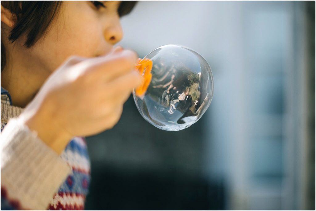 profile shot of little boy blowing a soap bubble