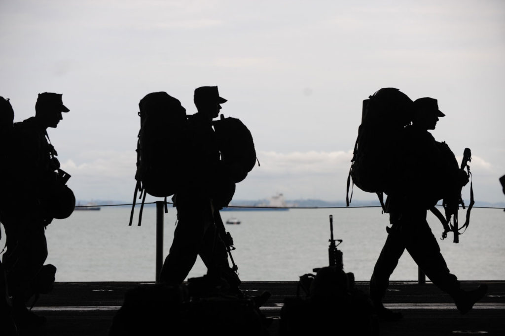line of soldiers walking silhouetted