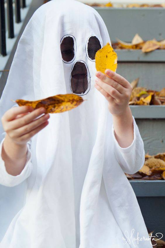 kids costume diy of ghost with kid holding leaves