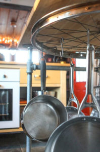 pots and pans hanging in kitchen from old upcycled bike wheel