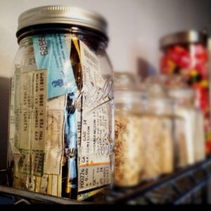 mason jar filled with ticket stubs on a shelf