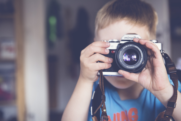 little kid with camera to his face