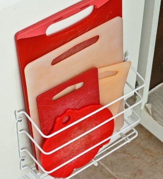 cutting boards in basket in cupboard