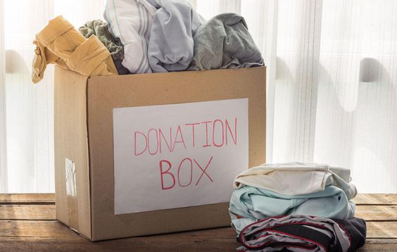 box with donation sign filled with clothes