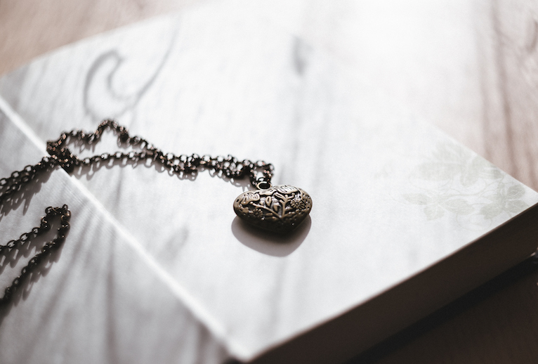 heirloom heart necklace on chain atop a book