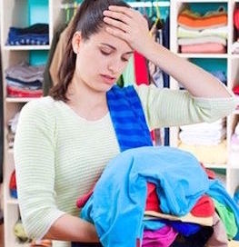 frustrated woman holding a pile of clothes