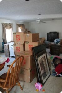 boxes in living room surrounded by clutter