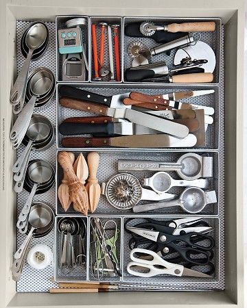 aerial view of open kitchen drawer with cooking tools and measuring spoons