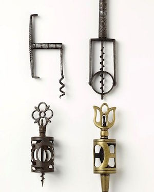 4 old fashioned corkscrews laying flat against white background