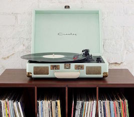 light blue record player atop a bookshelf filled with records