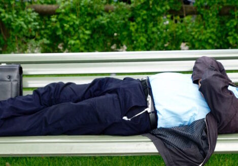 older well-dressed man napping on park bench