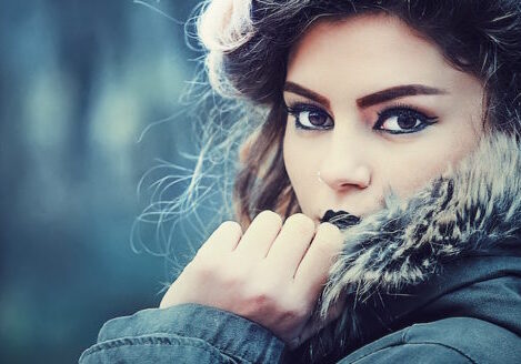 closeup of girl in winter coat looking over her collar